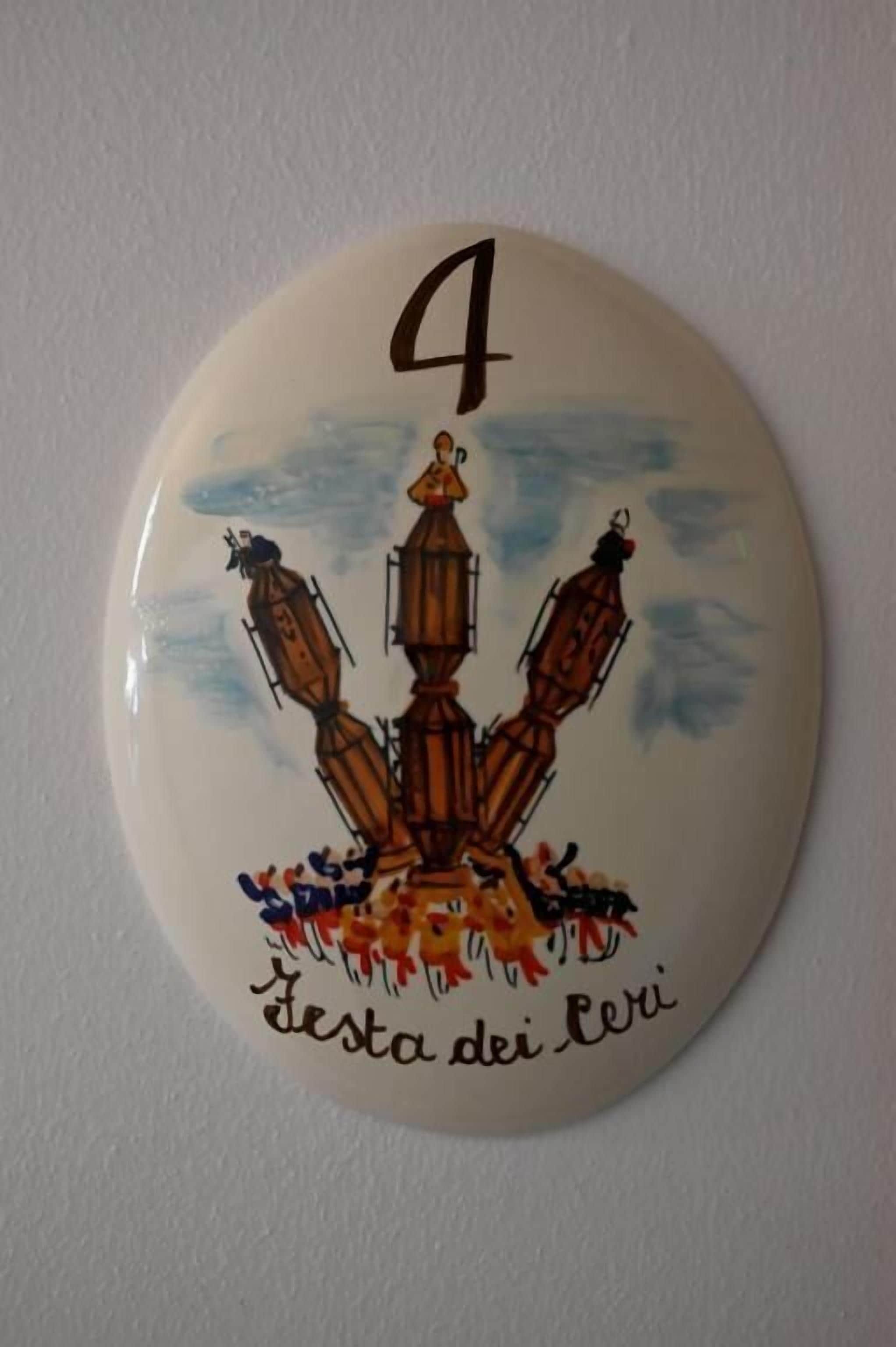 Una placa redonda con el número 4 y el texto 'Festa dei Trevi' en una pared.