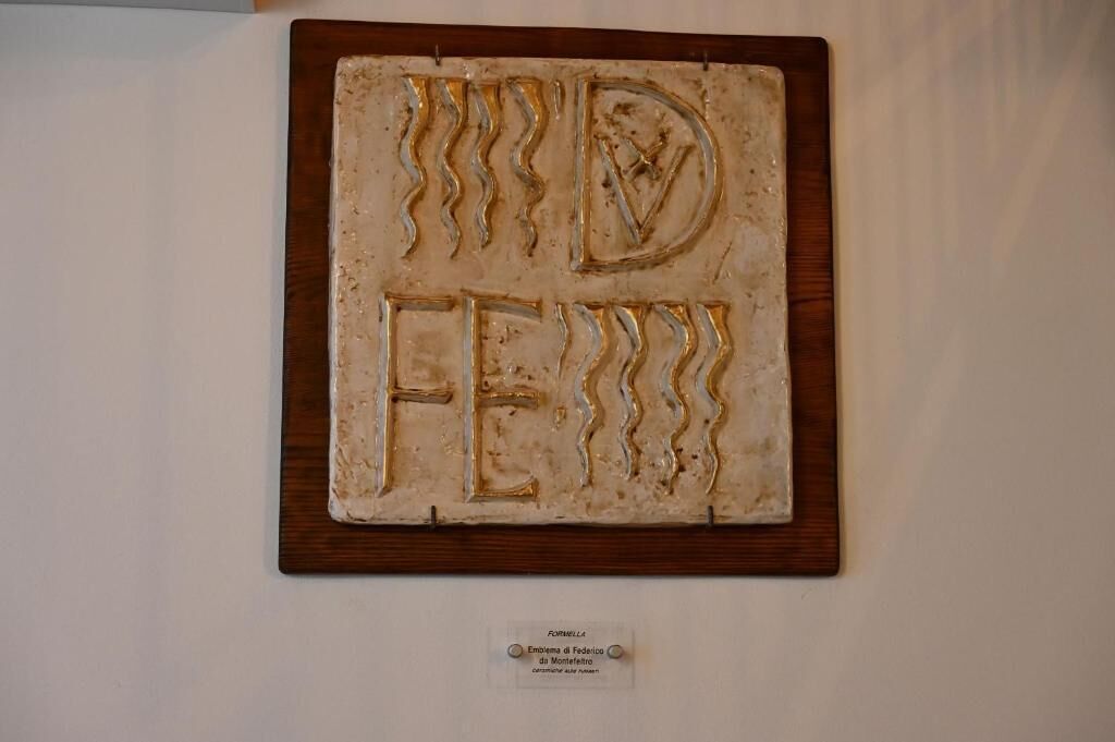 A textured wall art piece with the inscription 'FEDERICO' mounted on a wooden frame.