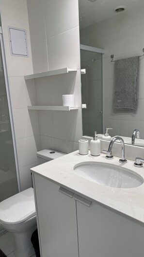 Ein modernes Badezimmer mit Toilette, Waschbecken und Dusche.