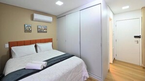 Un dormitorio con cama, armario y puerta.