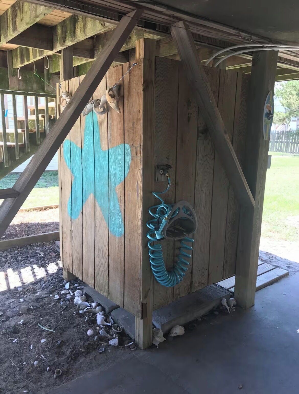 A wooden structure with a star painted on it, a coiled hose, and a small animal figure.