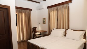 A hotel room with a wooden bed, a wooden desk, and a chair. - VillaStarova (Berat)