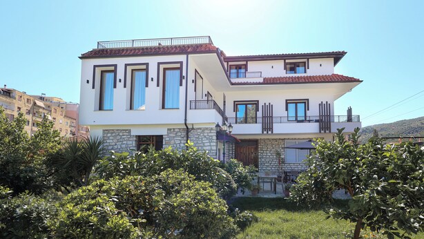 A two-story building with a balcony and a stone facade. - VillaStarova (Berat)