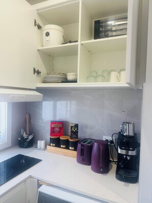 A kitchen with white cabinets, a coffee maker, and a toaster. - Bright and Cozy suite for 4 guest, feel like a home with Molonglo valley views (Whitlam)