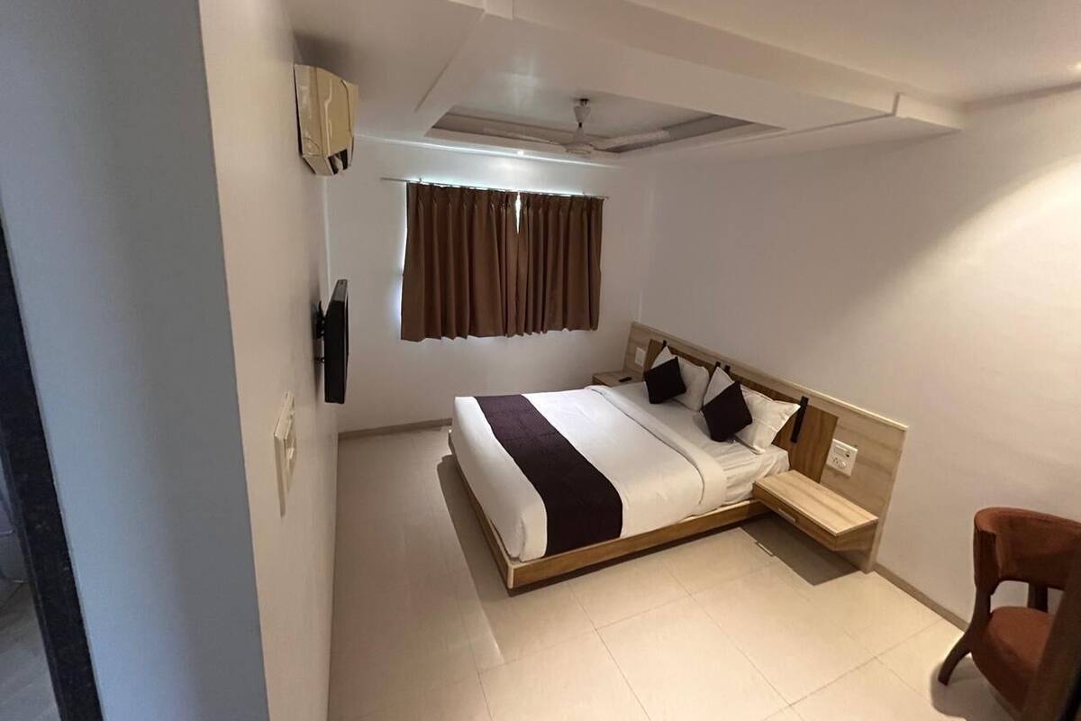 Un dormitorio con cama, mesita de noche, silla y ventilador de techo.