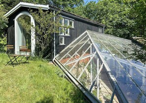 Una casa de madera con una amplia estructura de invernadero.