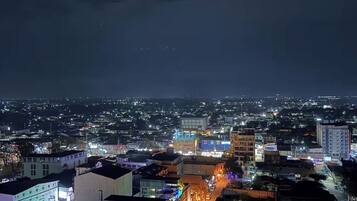 A nighttime cityscape with illuminated buildings and a river.