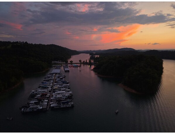 A marina with boats docked along a riverbank during sunset.