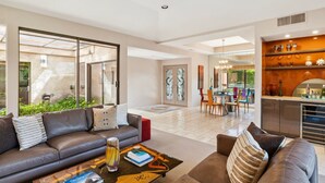 Ein modernes Wohnzimmer mit einer Couch, einem Couchtisch und einem Essbereich mit Stühlen und einem Tisch.