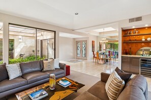 Ein modernes Wohnzimmer mit einer Couch, einem Couchtisch und einem Essbereich mit Stühlen und einem Tisch.