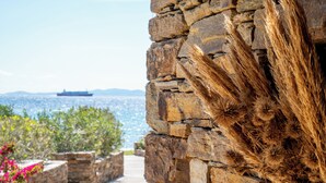 Eine Steinsäule mit Blick auf das Meer und einem Schiff in der Ferne.