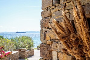 Eine Steinsäule mit Blick auf das Meer und einem Schiff in der Ferne.