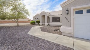A residential building with a garage, a driveway, and a landscaped area with a tree and shrubs. - Lakefront retreat w/Private pool- Winter/Mid-Term visitor discount available (Fort Mohave)