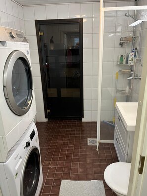 Pesutila, jossa on pesukone ja kuivausrumpu, suihkukaappi ja wc.