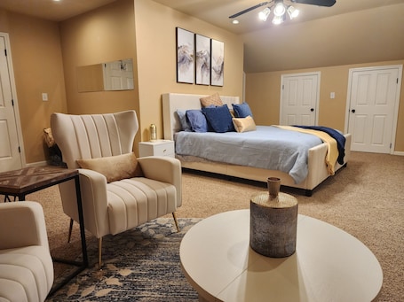 A bedroom with a bed, a chair, a small table, and a ceiling fan.. River House with dock & boat slip, perfect for Alabama & Mississippi game days