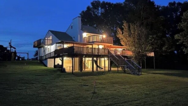 A two-story house with a balcony and a staircase leading to the upper level. - River House with dock & boat slip, perfect for Alabama & Mississippi game days (Columbus)