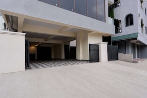 Un bâtiment doté d’une entrée abritée, d’une allée bordée de portails et d’un sol carrelé.