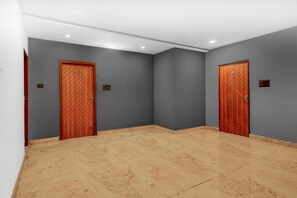 A hallway with two doors, each marked with a number plate, and a tiled floor. - Suite Room Health Visakhapatnam Nebo (Visakhapatnam)