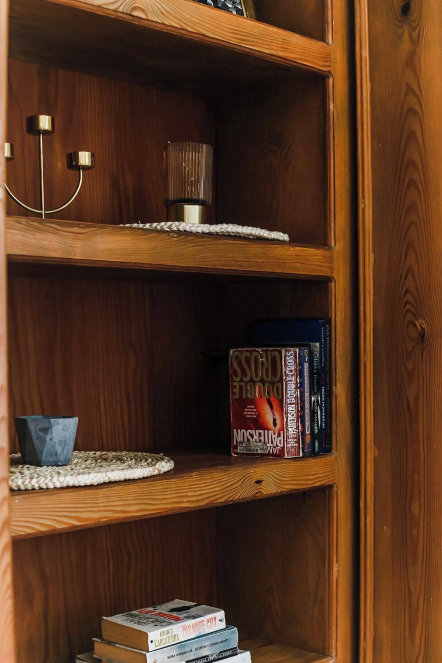 Una estantería de madera con libros y adornos.