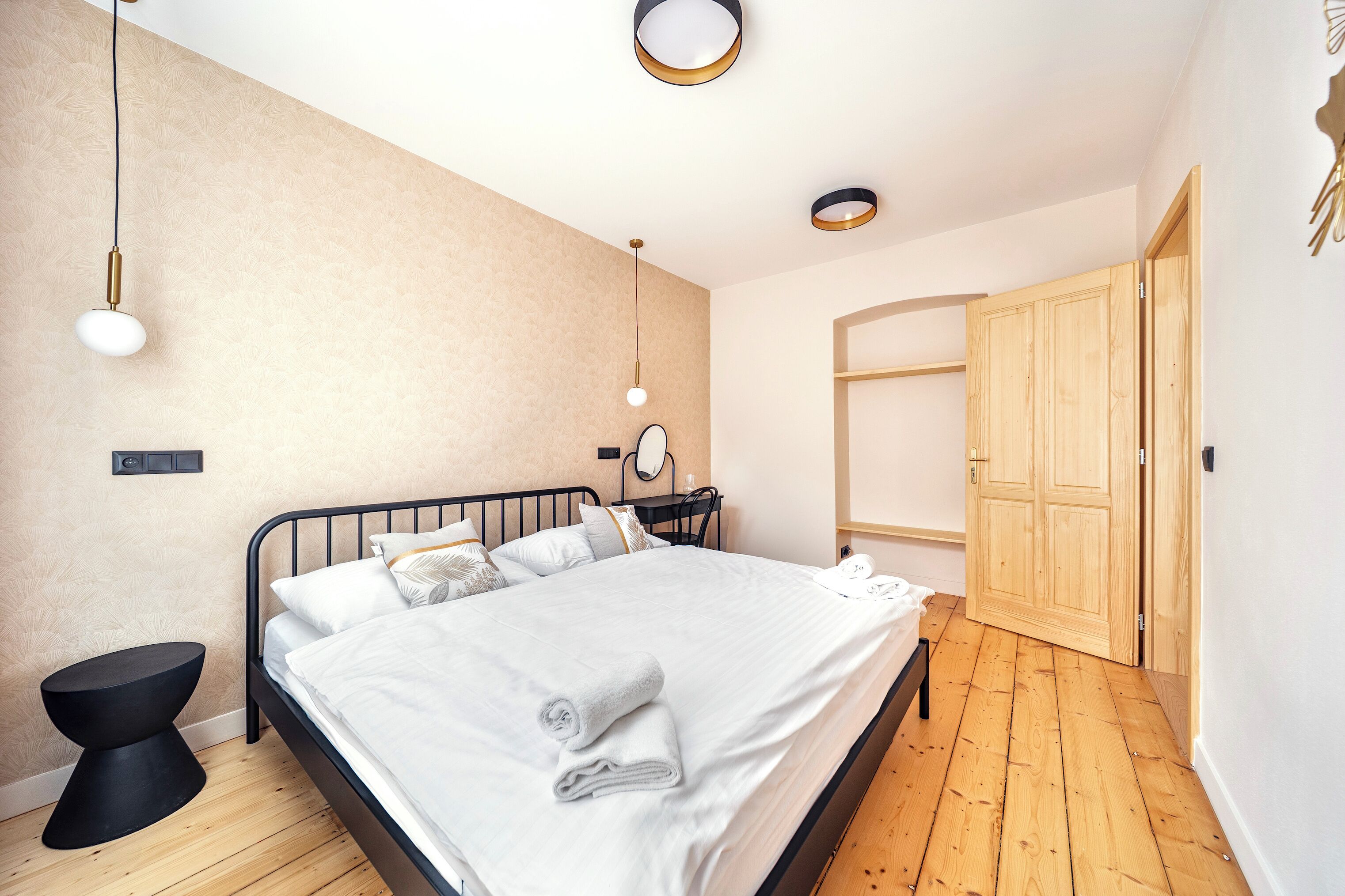Ein Schlafzimmer mit Bett, Nachttisch, Wandlampe und einem Holzschrank.