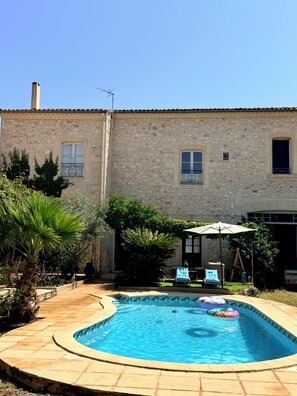 A stone building with a swimming pool, outdoor seating, and a clear sky. - Winegrower's house 500m² - Swimming pool - Baillargues - 12 pers. (Baillargues)