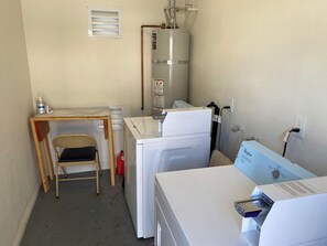 Ein Waschraum mit Waschmaschine, Trockner und Warmwasserbereiter.
