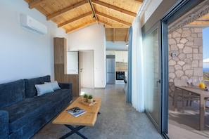 Ein modernes Interieur mit Holzbalkendecke, einer Couch, einem Couchtisch und einer Steinwand.
