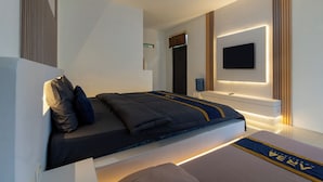 Un dormitorio moderno con cama, televisor de pantalla plana y dispensador de agua.