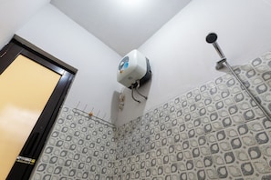 A bathroom with a shower, a towel rack, and a wall-mounted air conditioner.