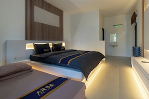 Una habitación de hotel con cama, mesita de noche y televisor montado en la pared.