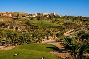 A golf course with a clubhouse in the background.