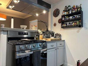 Eine Küche mit Herd, Backofen und diversen Küchenutensilien.
