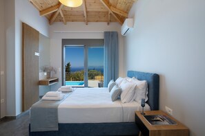 A bedroom with a large bed, a nightstand, a window with a view, and a wooden ceiling. - Ionian Harmony Villa 1 | Private Pool & Sea View (Tsoukalades)
