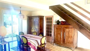 A dining area with a table, chairs, a cabinet, and a staircase. - House in Penestin, located 350 m from the beach (Penestin)