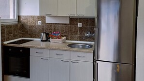 Una cucina con un frigorifero in acciaio inox, un lavello e una finestra.