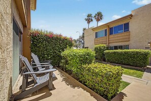 A courtyard with outdoor seating, a hedge, and a building with a number 379 sign. - NEW|Camelback 352|Resort-Style Stay Near Old Town (Scottsdale)