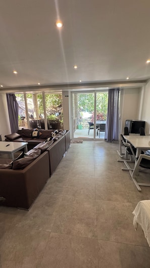 A modern living room with a sofa set, a dining table, and a TV. - PILI BEACH RESORT AGMANIC (Santa Fe)