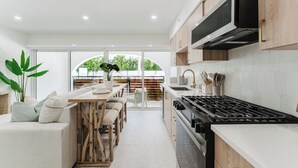 Uma cozinha moderna com fogão, micro-ondas e armários de madeira.