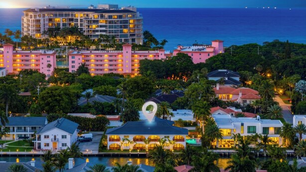 Um hotel à beira-mar com vários edifícios, uma piscina e vista para o oceano.