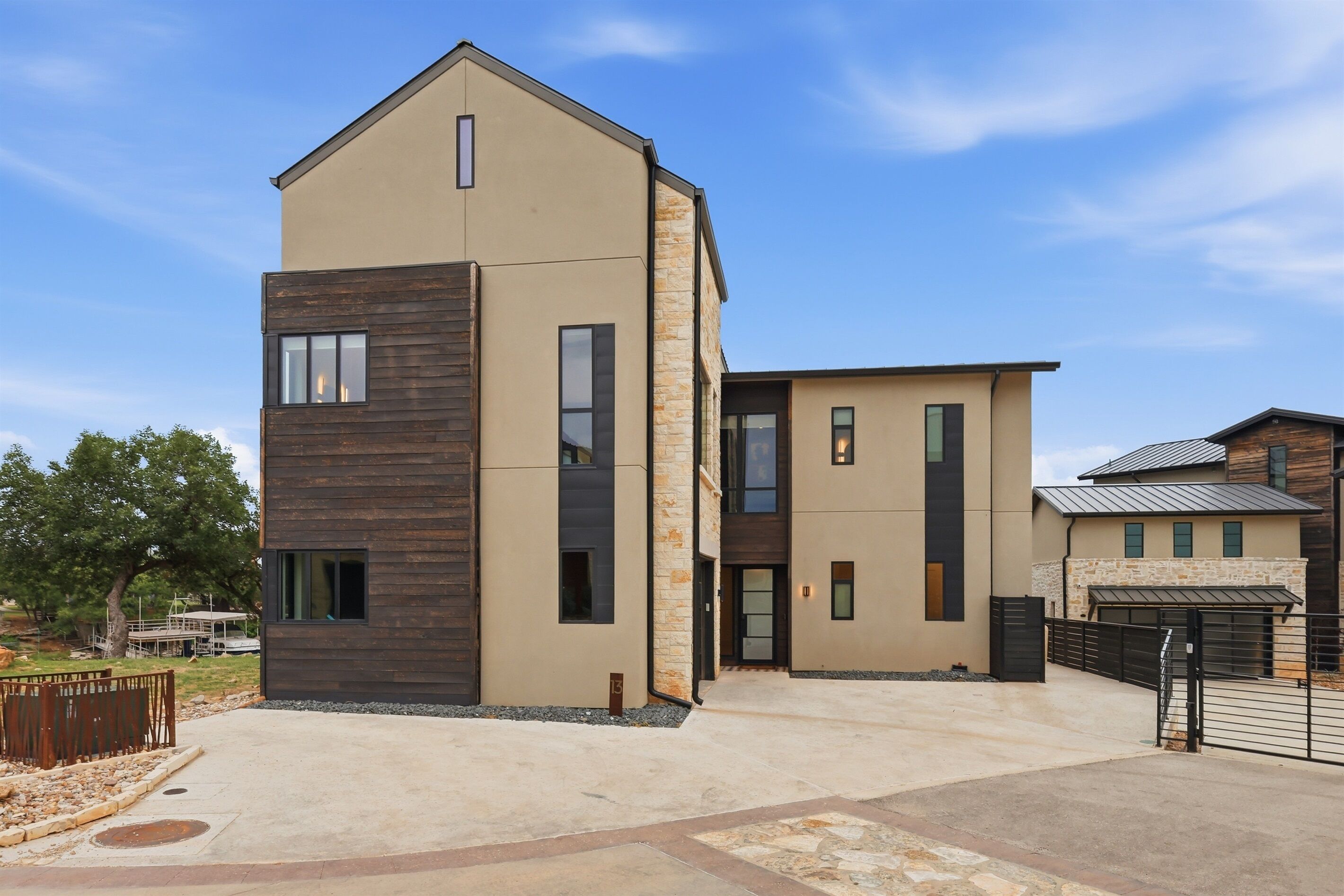 A modern two-story building with a flat roof, large windows, and a stone facade.