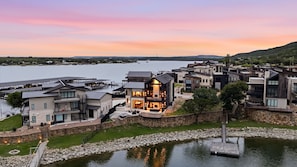 A lakeside residential area with modern houses, a dock, and a stone wall.