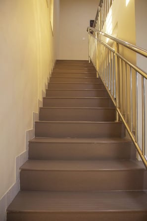 A staircase with a handrail, leading upwards.
