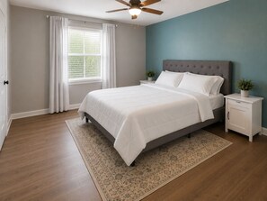 A bedroom with a bed, nightstands, a ceiling fan, a window with curtains, and a rug. - Lovely 1-bedroom townhome with AC in pleasant Tallahassee (Tallahassee)