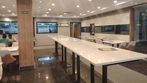 A self-service area with a long counter, seating, and a sign indicating self-service. - Varsha Grand  (Hyderabad)