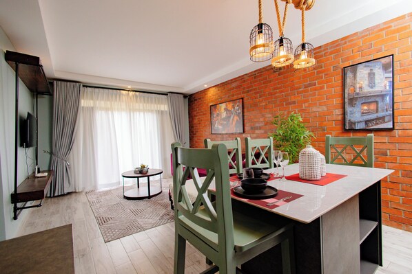 Un comedor con pared de ladrillo, chimenea y una mesa dispuesta para cuatro.