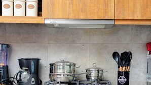 A kitchen with a built-in oven, a coffee maker, and a pot on the stove. - Rustic, quiet and cozy 1-bedroom condo with fantastic views. (Kampala)