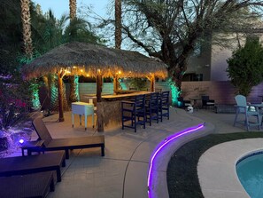 A thatched outdoor bar area with seating and a pool. - The Mojave Tiki Mirage With Pool - North Las Vegas (North Las Vegas)
