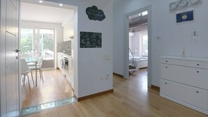 Eine moderne Küche mit Essbereich, einer Waschküche und einem Schlafzimmer mit Bett und Kommode.