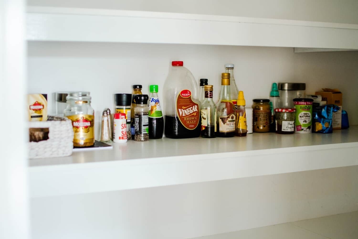 Une étagère contenant divers produits alimentaires et condiments.