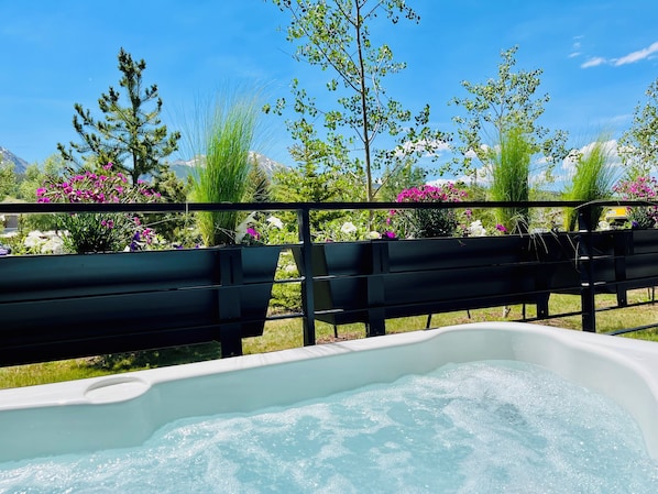 Un jacuzzi con vistas despejadas a un jardín lleno de plantas y flores.